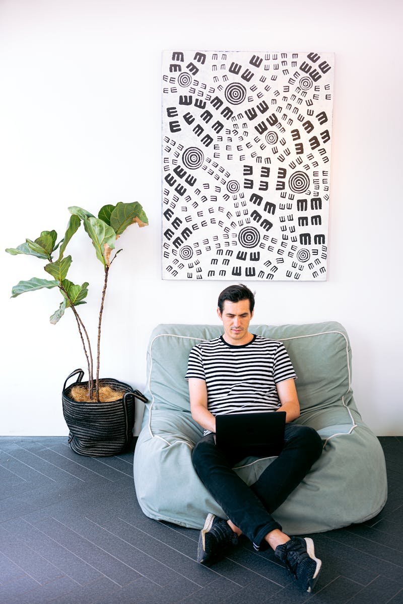 Pedro Serrano Málaga Young man working on laptop in stylish home office setting with modern decor.